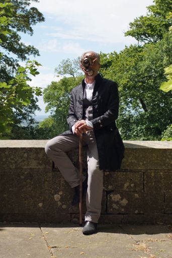 A vertical shot of a senior male in a costume at the Steampunk Event at Belvoire Castle Lincolnshire