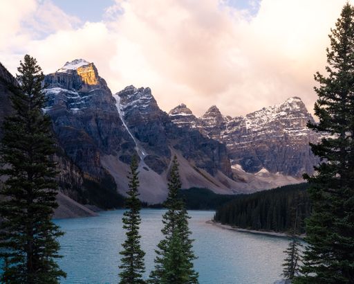 A small lake surrounded by mountains at Banff National Park against a cloudy sky in Canada