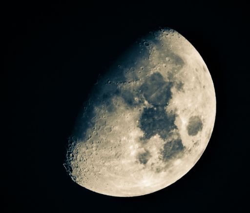 A waxing gibbous moon over dark sky at night