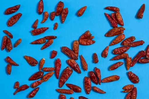 A high angle shot of some red chili peppers on a blue surface