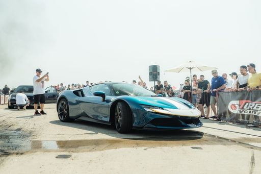 A cool blue car and a group of people during the Drag Racing event at the Arad International Airport