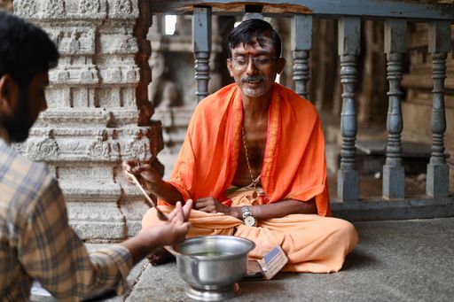A selective focus of a hindu priest in pure hindu attire at Virupaksha Temple.