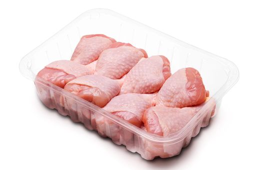 Chicken thighs raw in plastic tray isolated on white