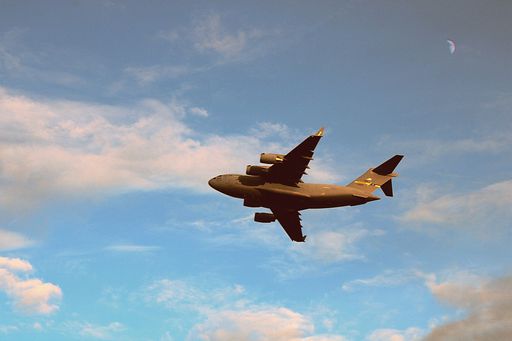 A low angle shot of an airplane flying in a blue sky