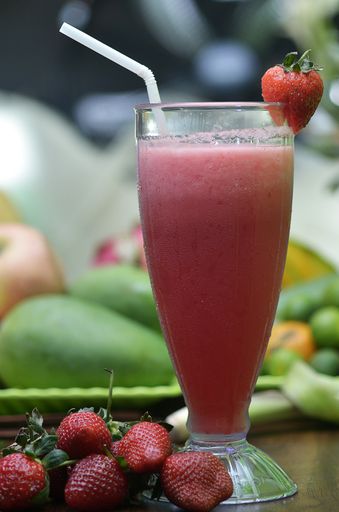 A vertical shot of a glass of strawberry juice