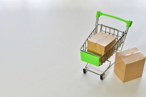 A small shopping cart with boxes on a white background - online shopping concept