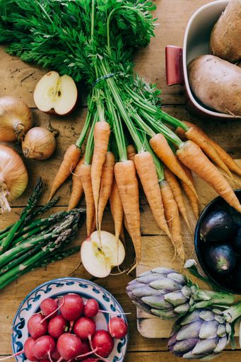 A vertical top view of fruits and vegetables on a wooden table