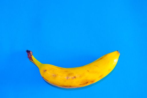 A high angle shot of a fresh banana isolated on a blue surface