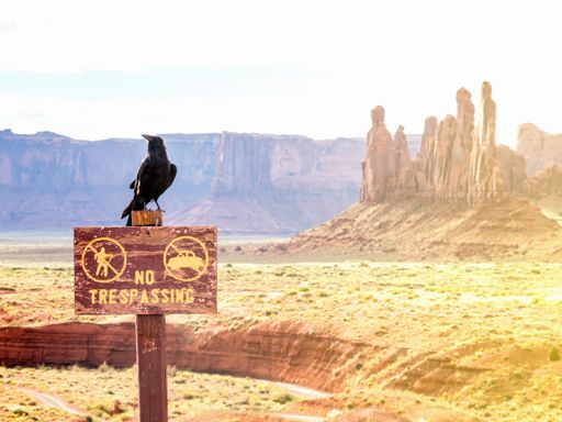 A closeup shot of  No trespassing sign and a crow in Monument Valley, Utah in USA