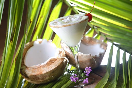 A closeup of a glass of pina colada with a cherry on top on the table