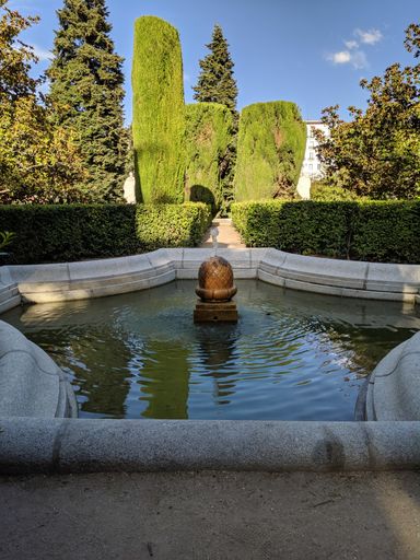 A vertical shot of a fountain in The Sabatini Gardens of the Royal Palace in Madrid, Spain