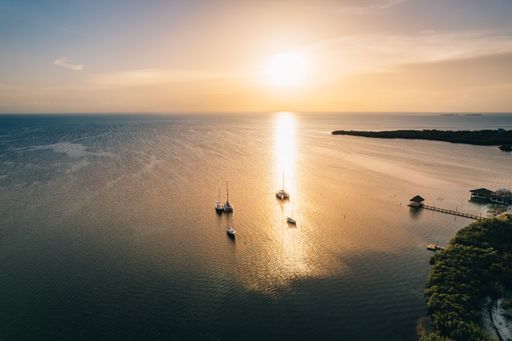 An aerial shot of the split at Caye Caulker with sailing boats at a beautiful sunset, Belize