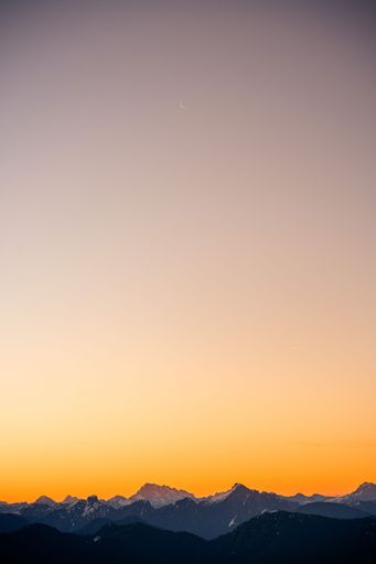 A beautiful view of huge mountains during orange sunset