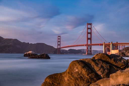 A scenic view of the Golden Gates bridge against mountains and sea shot in long exposure in San Francisco