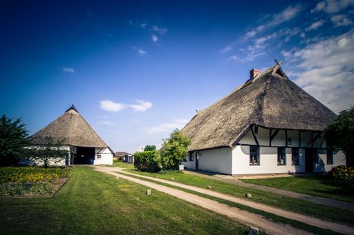 A beautiful shot of a white one floor house with dark roof in a village