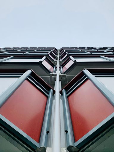 A vertical low-angle shot of red windows in the city of Bergen, Norway