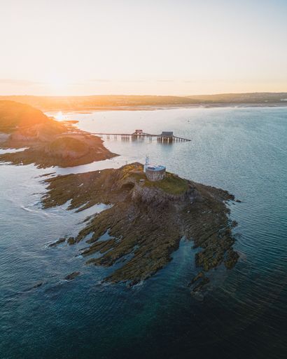 A vertical shot of the Mumbles Lighthouse at sunset