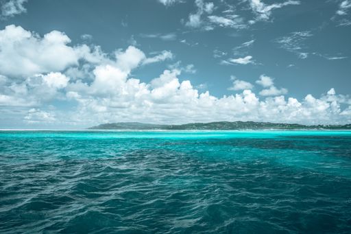 A beautiful tropical bay with clear turquoise water under a cloudy sky