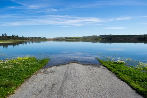 A high angle shot of a lakeshore under the clear sky reflecting in the water