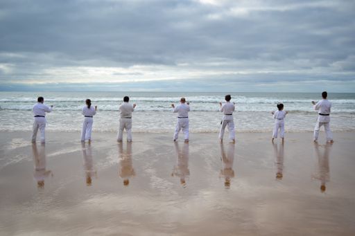 A beautiful shot of karate players practicing at the seashore
