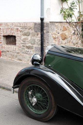 A vertical shot of an old green vintage car