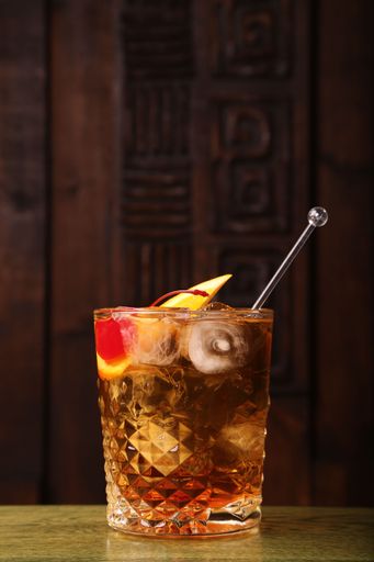 A vertical closeup of an Old Fashioned cocktail.