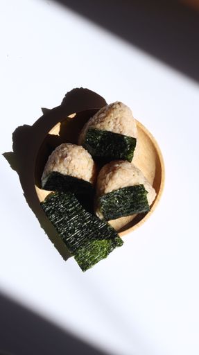 A vertical shot of sushi from onigiri rice on the white background