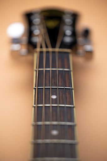 A Vertical shot of an acoustic guitar neck from the Ibanez brand.