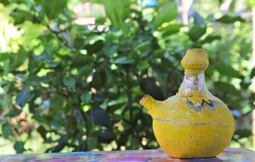 A selective focus shot of colorful handmade objects with the garden in the background