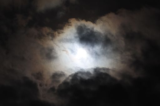 The stunning bright sun behind dark gloomy clouds