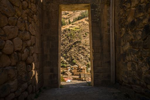 A closeup of a window looking to the townscape with brick walls, an archeological site in Peru
