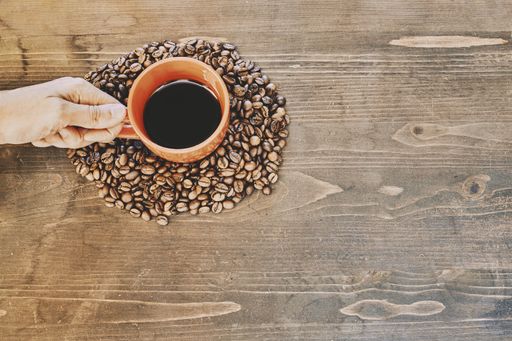 A top view of a cup of coffee on a wooden table