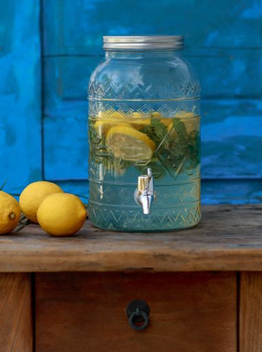A vertical shot of glass dispenser with lemon and mint drink