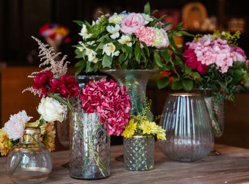 A beautiful shot of various fresh flowers in glass vases