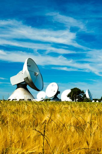 The Erdfunkstelle satellite station in Raisting, Germany with a yellow corn field under a blue sky