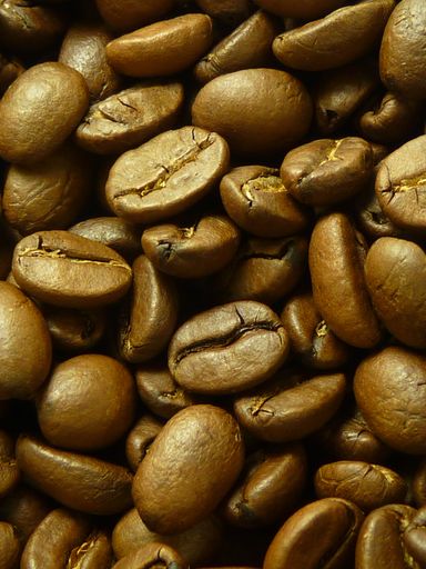 A vertical closeup shot of fresh brown coffee beans roasting