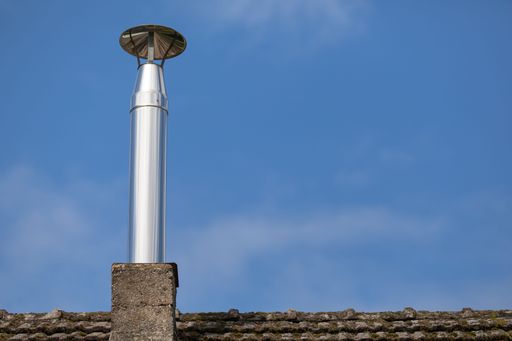 A steel pipe of roof chimney without smoke exhausts waste gas from traditional heater out of home