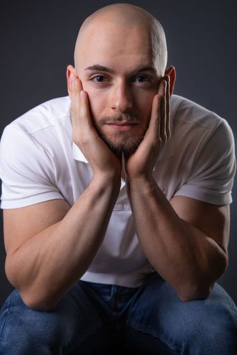 A handsome male in a studio posing for a photo on a black background