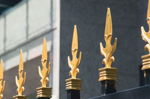 A closeup of golden fence heads
