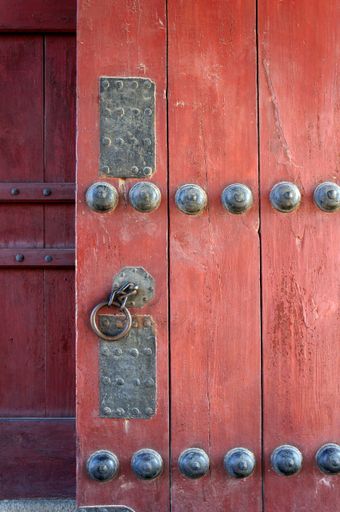 A vertical closeup shot of an old red door in South Korea