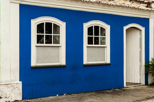 Nice facade. City of Porto Seguro. Bahia.Old house in blue color and white details with white wooden door and windows.