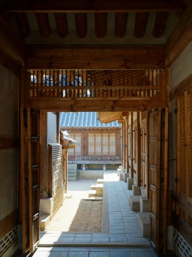 A vertical shot of an outdoor corridor of a historic building in South Korea