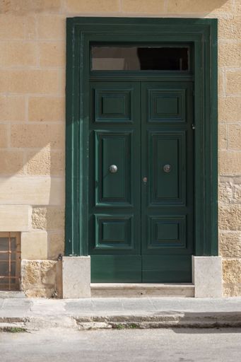 A vertical shot of a wooden door of an ancient building in Victoria, Gozo, Malta
