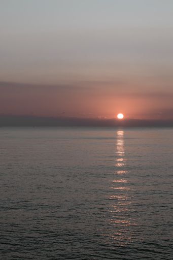 A vertical shot of a beautiful sunset reflecting on the sea