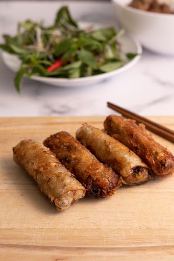 A vertical closeup shot of Asian rolls on a wooden board