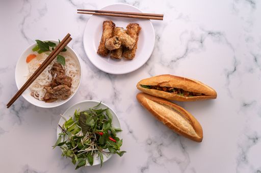 A high angle shot of different Asian dishes with chopsticks on a marble surface