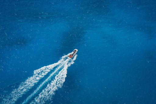 small boat drives into the blue sea of Greece