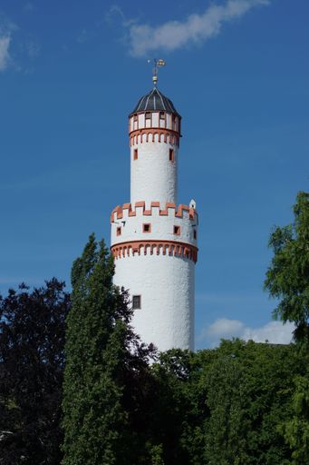 Keep of Bad Homburg Castle, Germany. The white tower framed by green trees against blue summer sky. A tourist attraction.