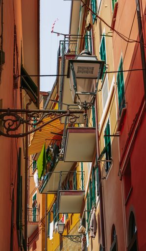 A vertical shot of a colorful building with balconies and windows in Riomaggiore village in Italy