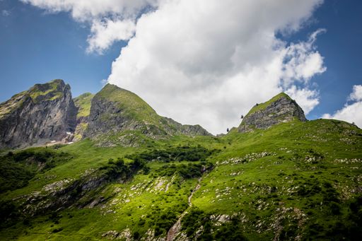 The beautiful view of the green mountains and cloudy blue sky.